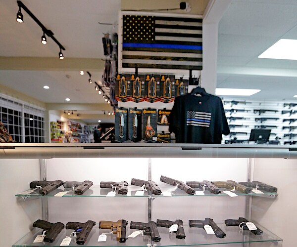 a gun shop displays a number of handguns and a shirt with the american flag