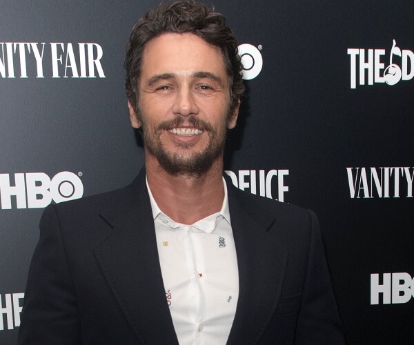 james franco stands on red carpet