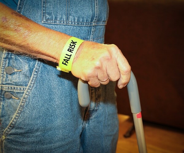 man with cane wears fall risk bracelet