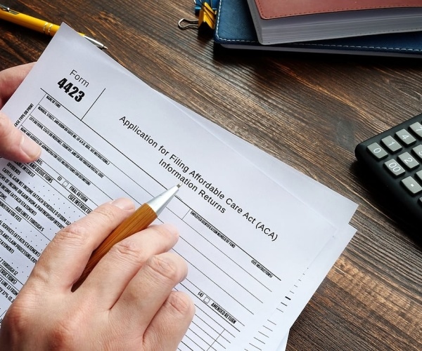 person filling out forms for ACA insurance