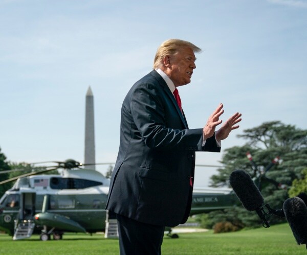 trump on the white house lawn with helicopter behind him and washington monument in the background