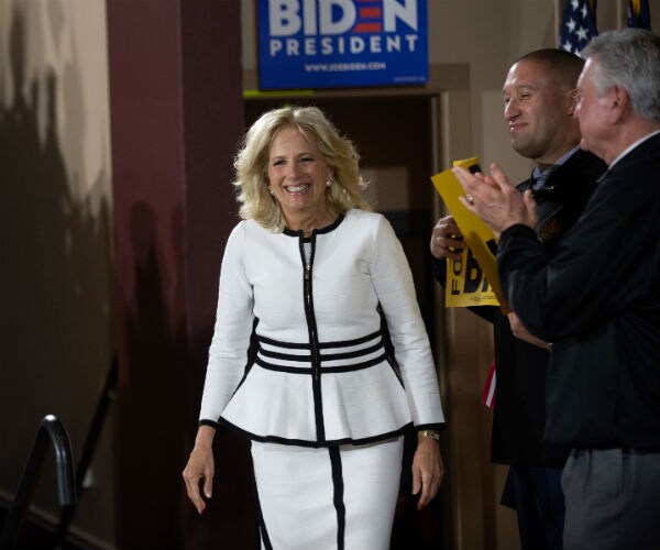 Jill Biden, wife of Joe Biden, speaks at a campaign rally for her husband in a white suit with black trim