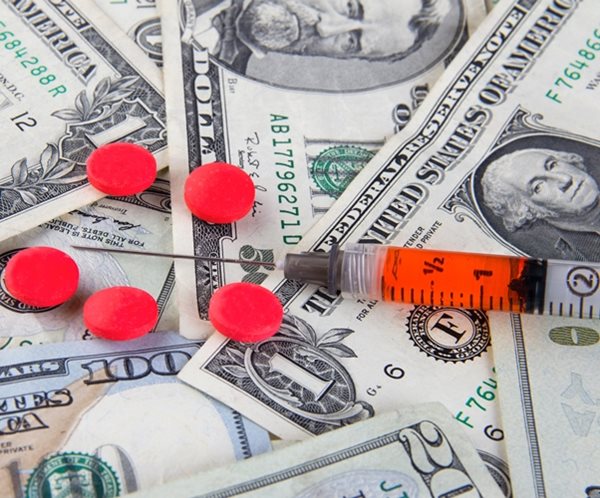 pills, medications and drugs scattered on various dollar bill american currency