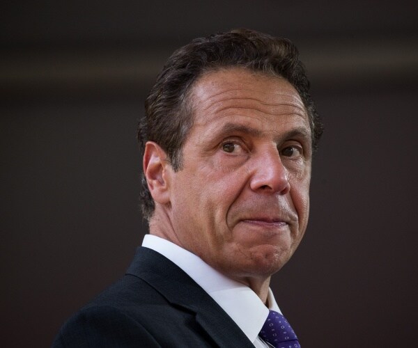 cuomo in a black suit and blue tie 