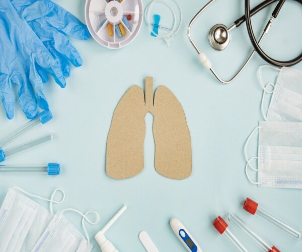 things on table representing COPD: cardboard lungs, stethoscope, pills...
