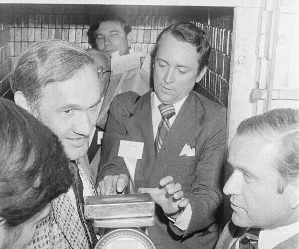 john conlan holds a gold bar