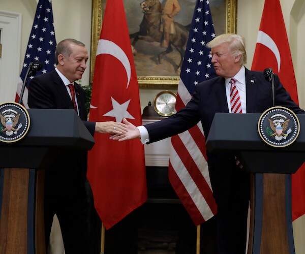 Turkey's Recep Tayyip Erdogan reaches out to shake the hand of President Donald Trump