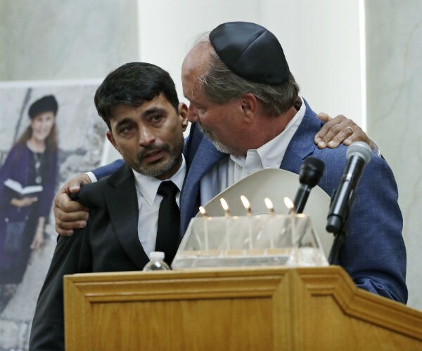 oscar stewart, center, is hugged by Steve Vaus, mayor of Poway, Calif., as they stand near Lori Kaye's photo Monday.