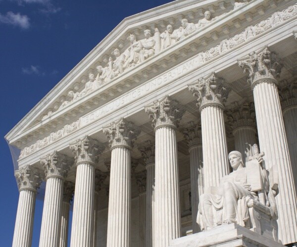 landscape view of us supreme court building with blue skies