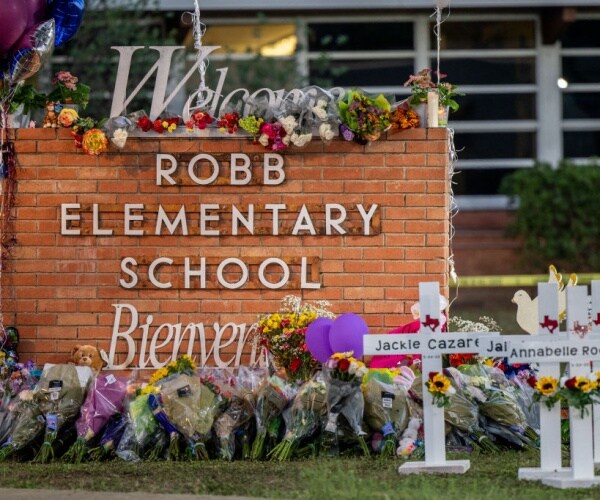 a memorial surrounding robb elementary school sign following the mass shooting in uvalde texas 