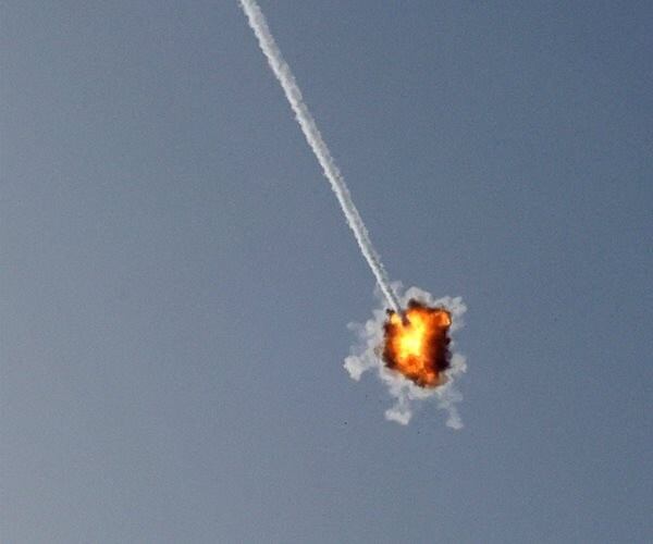 A vapor trail crosses the sky, ending in an explosion.