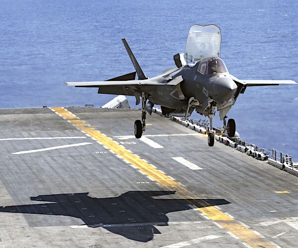 an american jet lands on an aircraft carrier