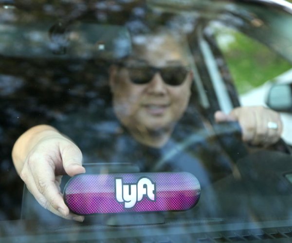 a lyft driver places an amp on his dashboard