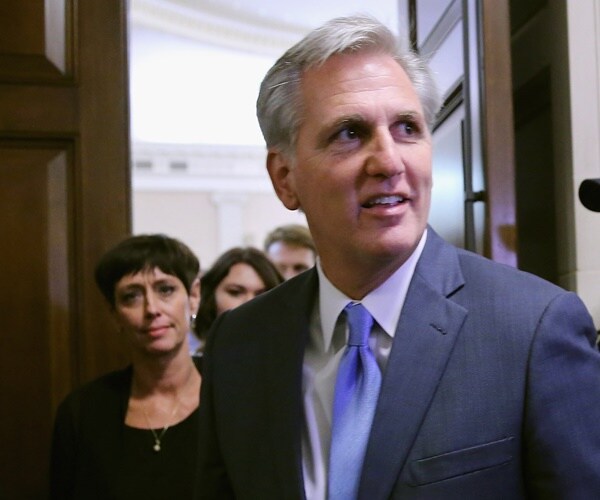 kevin mccarthy walks out of a caucus room