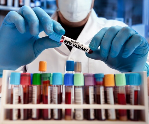 scientist in front of blood samples of new COVID variant