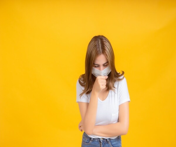 a young woman with mask coughing/sick