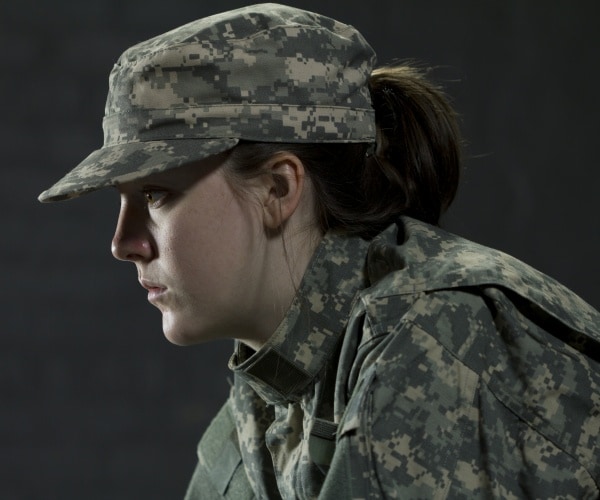 woman in fatigues looking sad