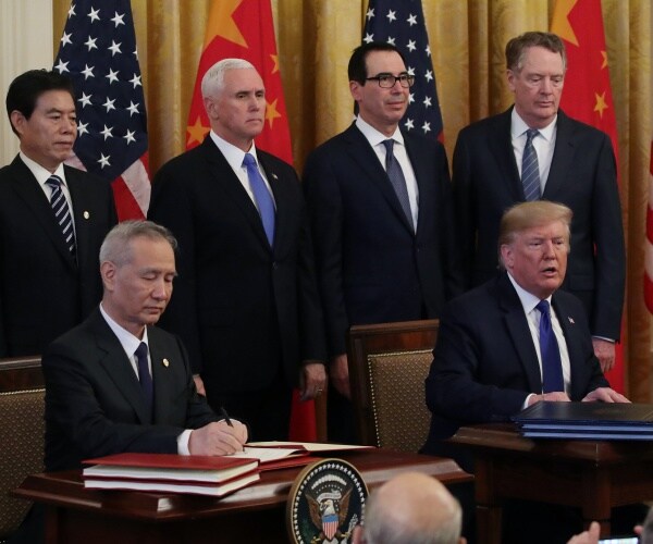 trump and liu he sign a deal with pence and mnuchin standing behind them and us and chinese flags