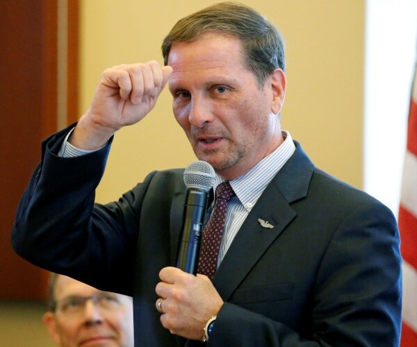 chris stewart speaks into a microphone