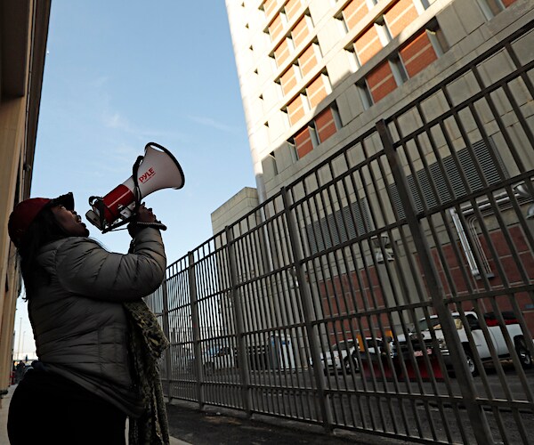 Catana Yehudah uses a megaphone to protest outside the Metropolitan Detention Center
