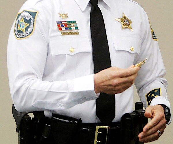 a sheriff's deputy is holding a sheriff's deputy badge
