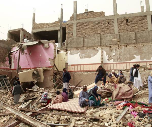 people walking in a bombed out building