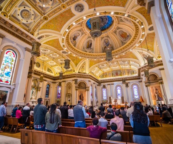 people attending mass at a large roman catholic church located in downtown san jose
