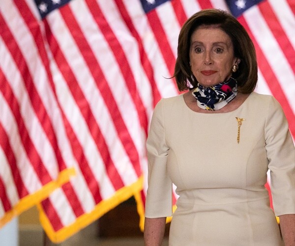 nancy pelosi wearing a mask sits in the hearing room