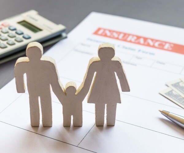 wood cutout of a family with insurance papers