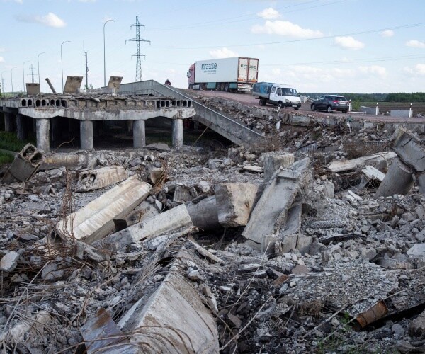 a car drives of a destroyed bridge