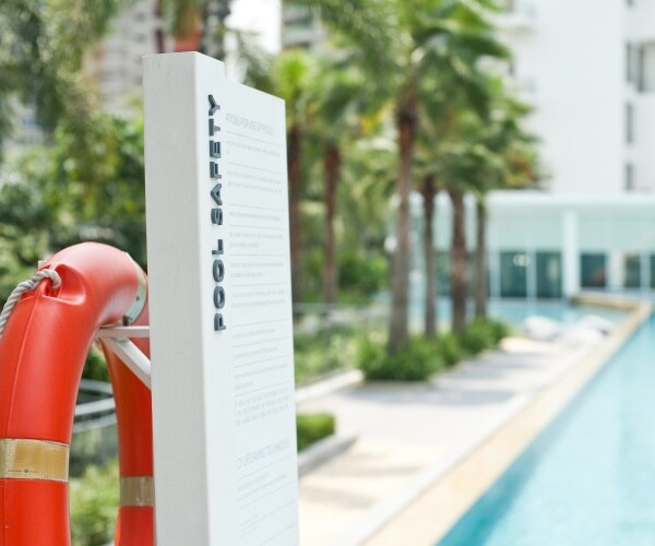 pool, sign that says 'pool safety' and lifesaving ring