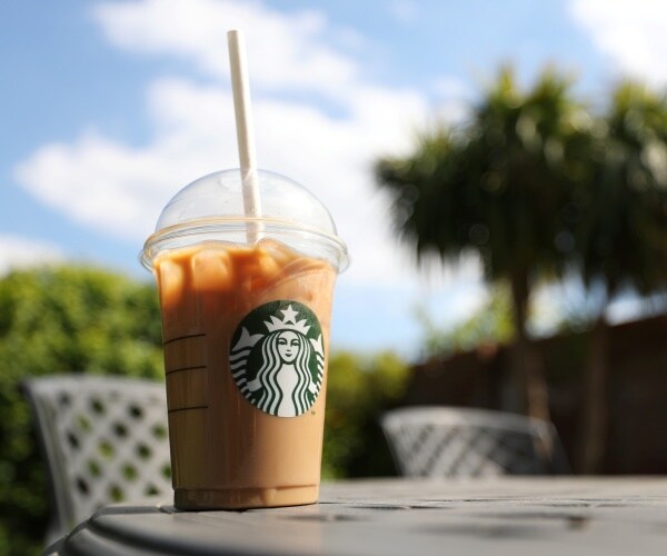 starbucks drink in a plastic cup sitting on a table outside