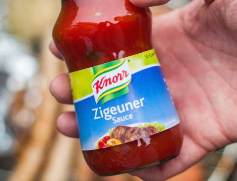 a hand holding a bottle of the sauce