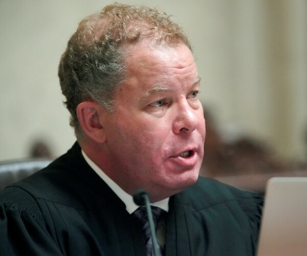 danile kelly speaks into a microphone