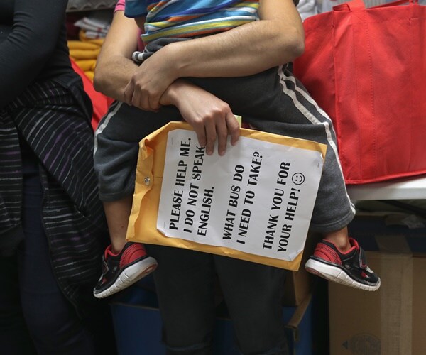 an immigrant woman carries her child with an envelop, saying she doesn't speak english