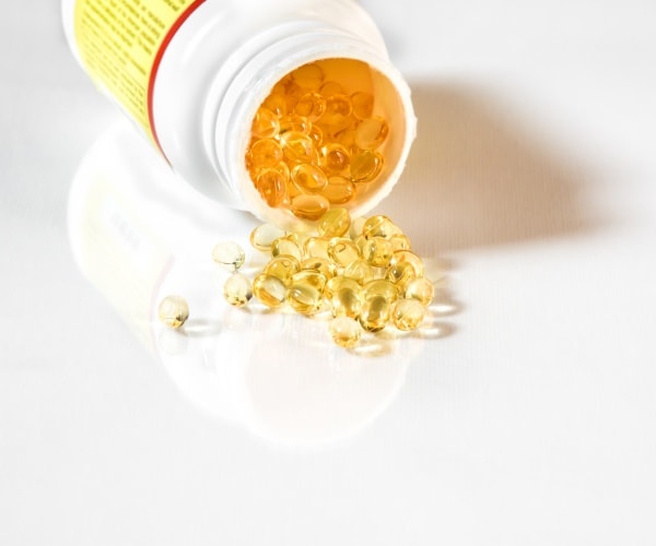 vitamin D supplements spilling out of container on to table