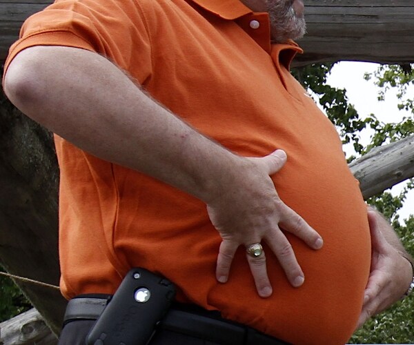 a man holds his oversized midsection with both hands