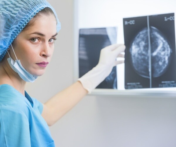 woman healthcare professional in scrubs looking at mammogram results