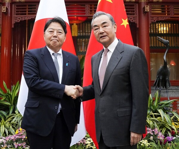 japanese foreign minister yoshimasa hayashi, left, shakes hands with china's top diplomat wang yi 