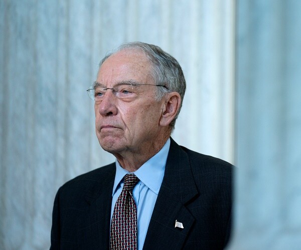 chuck grassley stands between pillars