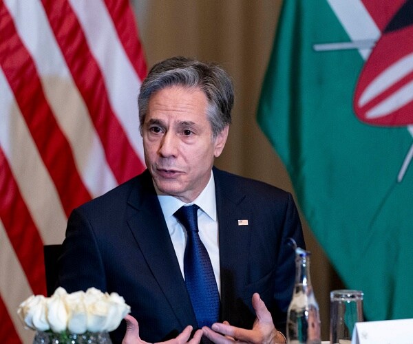 antony blinken sits at table