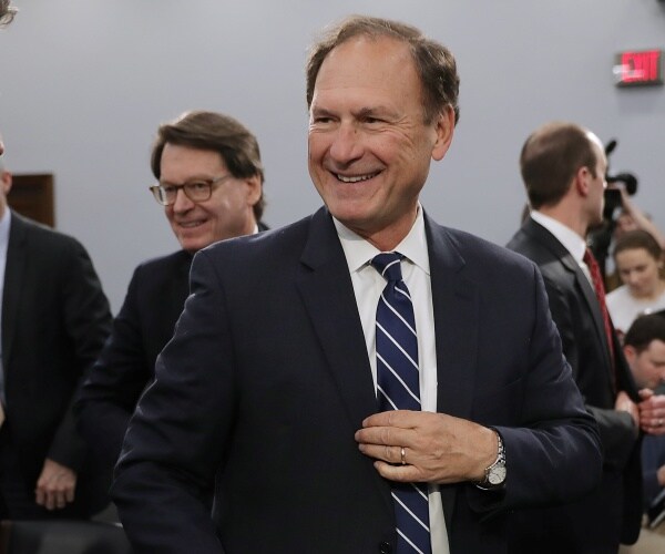 amuel alito smiles while standing