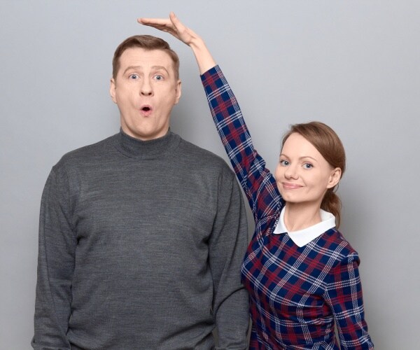 a tall man and shorter woman comparing heights