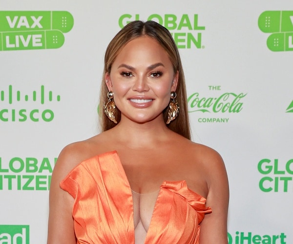 chrissy teigen stands on red carpet