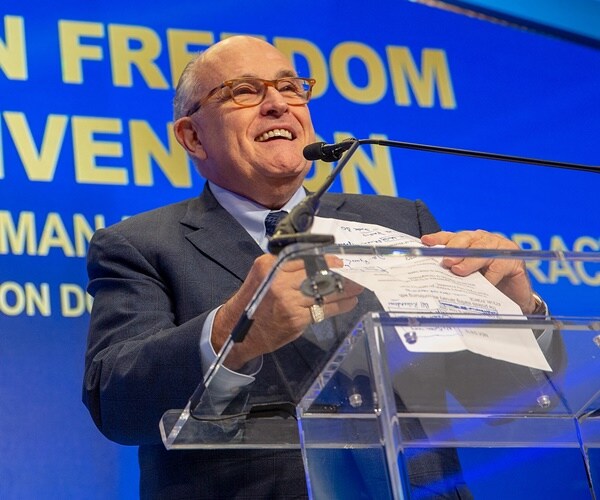 rudy giuliani looks up and smiles as he speaks during a convention