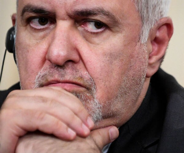 Iranian Foreign Minister Mohammad Javad Zarif props his hands under his chin while in deep thought.