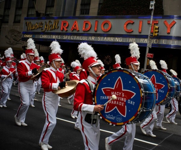Revelers makes their way down the Avenue of the Americas in front of Radio City Music Hall.