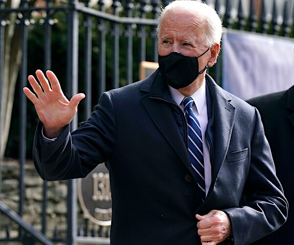 President Joe Biden waves as he departs after attending Mass at Holy Trinity Catholic Church on Sunday