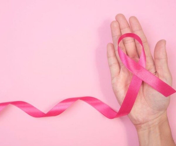 hand holding pink ribbon for breast cancer awareness