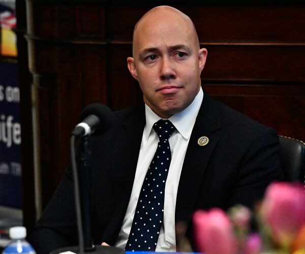 Congressman Brian Mast appears on Urban View's Helping Our Heroes Special dressed in black suit, white dress shirt. 